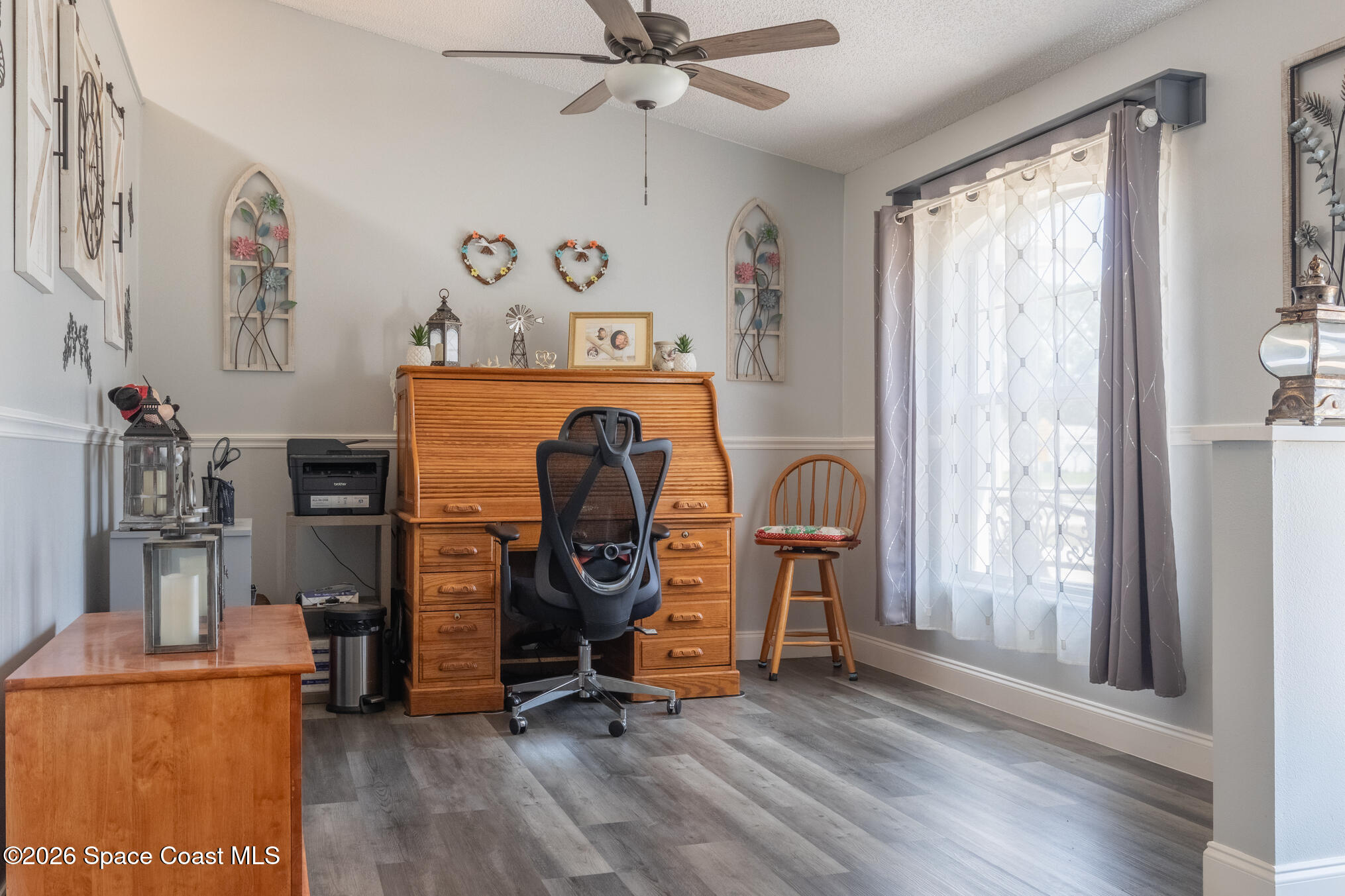 7210 Barbara Road Cocoa, FL 32927 - Photo 3 of 8 a view of workspace with wooden floor windows ceiling fan and windows
