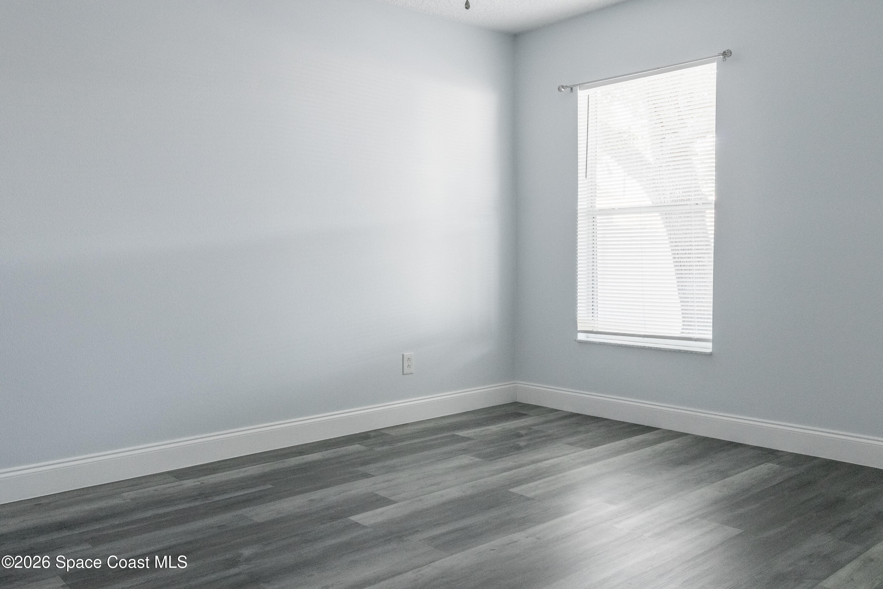 7210 Barbara Road Cocoa, FL 32927 - Photo 8 of 8 an empty room with wooden floor and window