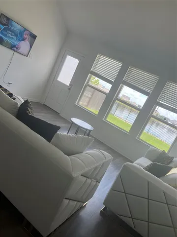 a living room with furniture and a floor to ceiling window