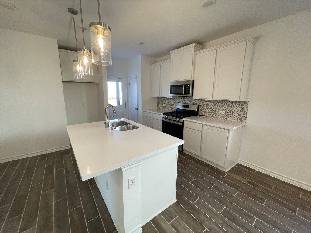 101 Thurman Holt Road Hutto, TX 78634 - Photo 17 of 38 a kitchen with sink a microwave and cabinets