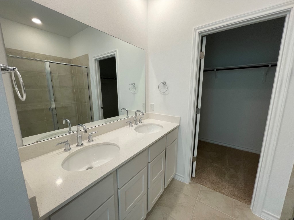 101 Thurman Holt Road Hutto, TX 78634 - Photo 22 of 38 a bathroom with a double vanity sink and mirror