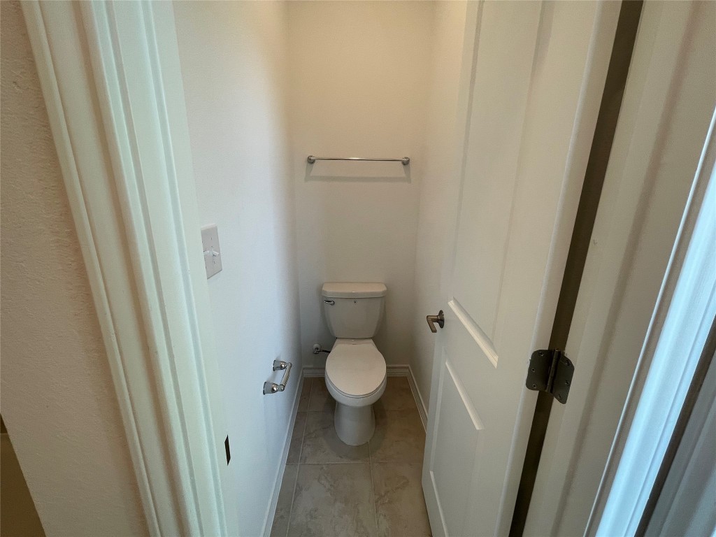 101 Thurman Holt Road Hutto, TX 78634 - Photo 24 of 38 a white toilet sitting next to a wooden floor