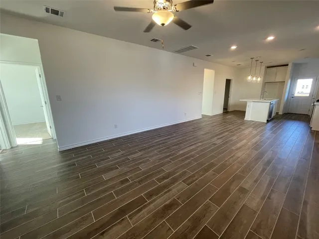 a view of a room with wooden floor and ceiling fan