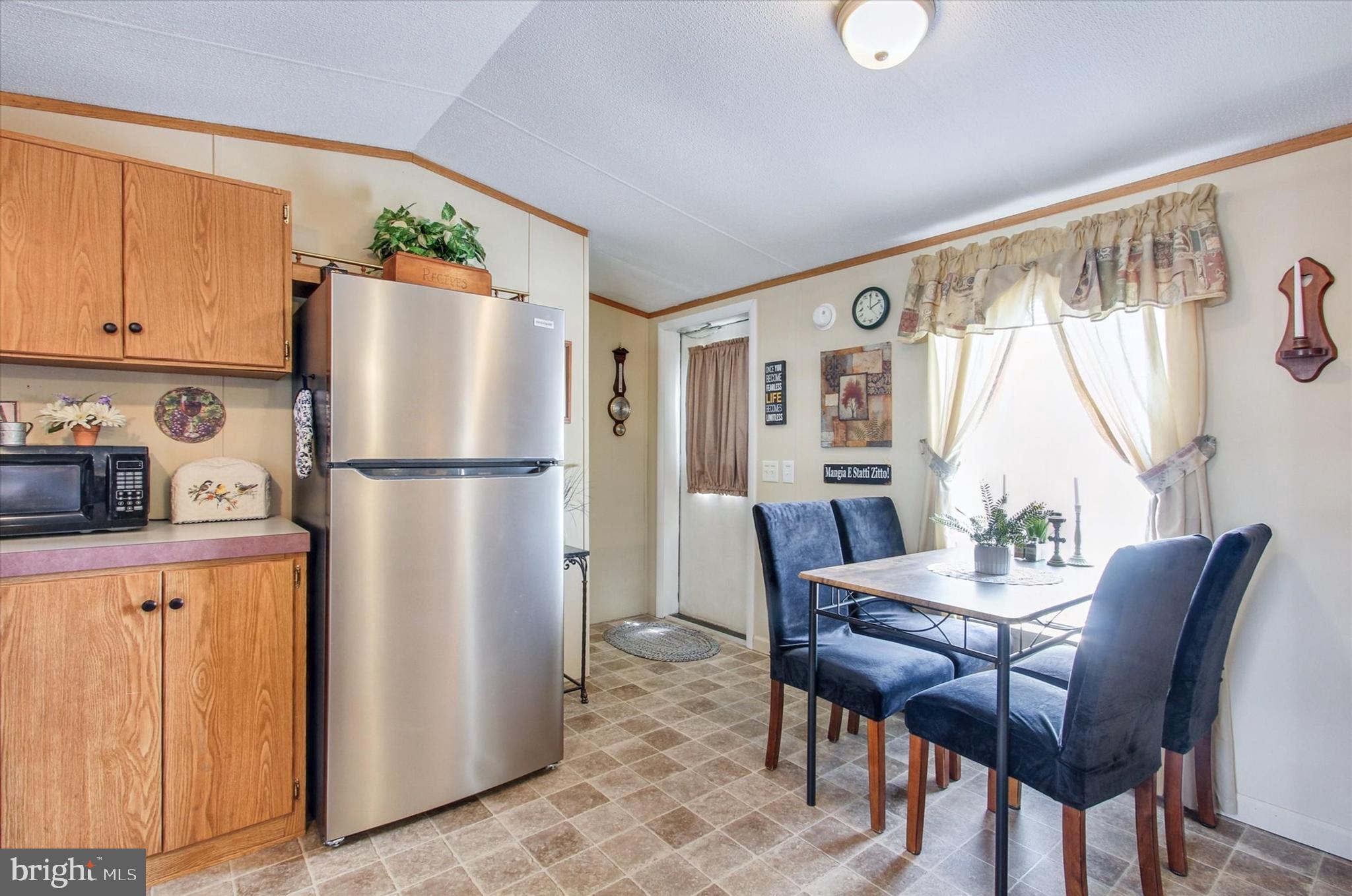 2215 Biglerville Road, Unit 15 Gettysburg, PA 17325 - Photo 11 of 21 a kitchen with stainless steel appliances refrigerator dining table and chairs