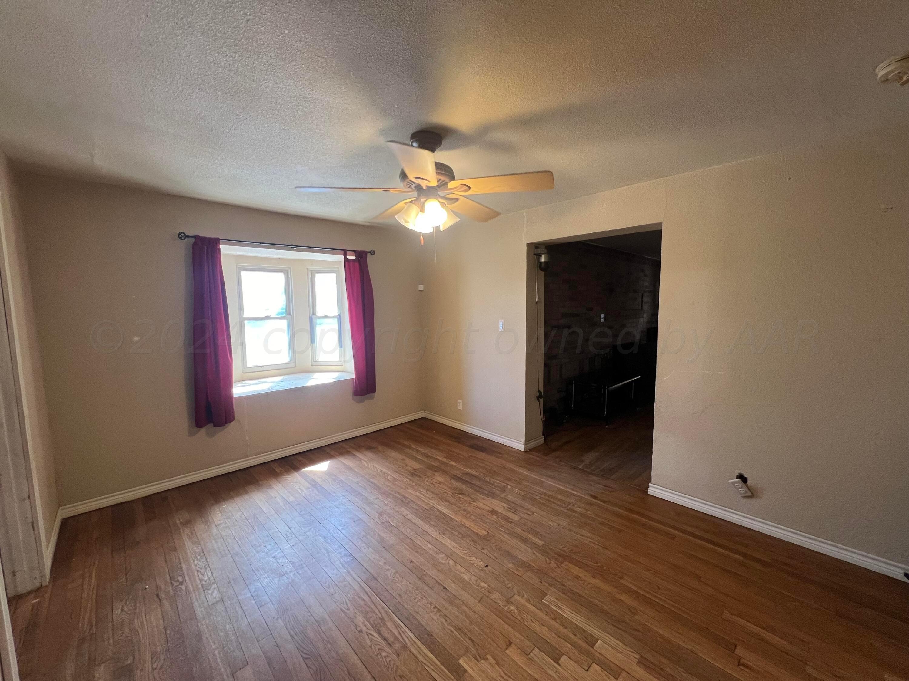 3811 South Polk Street Amarillo, TX 79110 - Photo 8 of 27 an empty room with wooden floor and windows