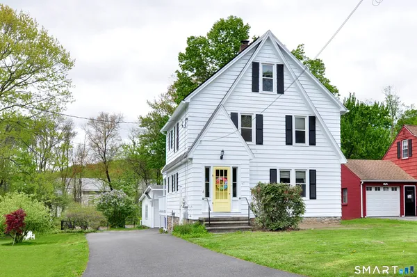 a front view of a house with a yard and trees