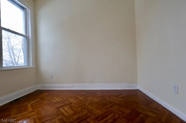a view of a room with wooden floor and windows in it