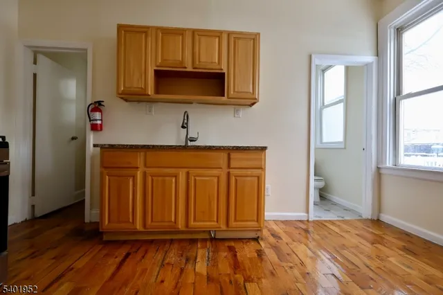 an entryway with wooden floor and cabinet