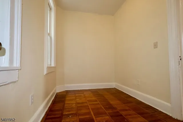 a view of a room with wooden floor and white walls