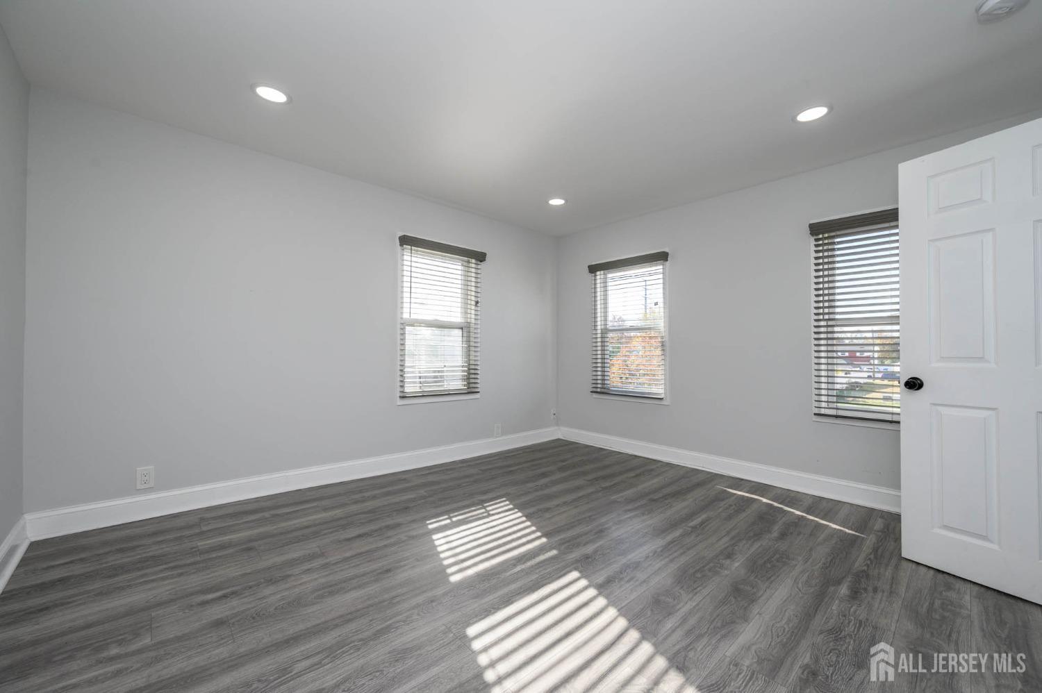 32 Lee Street Port Reading, NJ 07064 - Photo 17 of 32 a view of empty room with wooden floor and fan