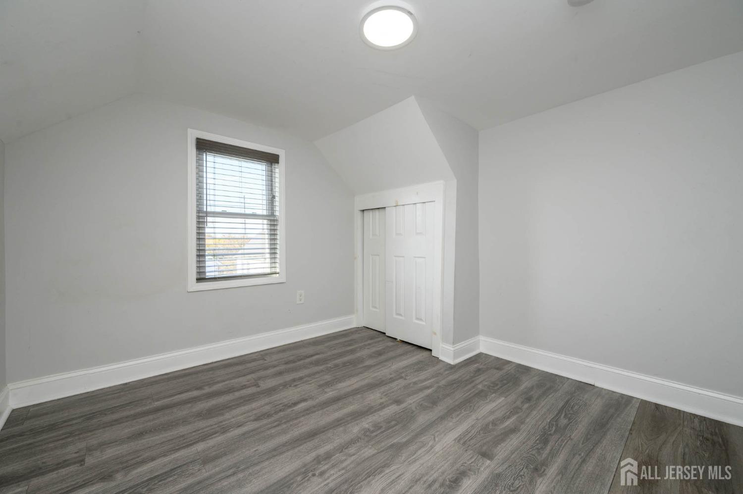 32 Lee Street Port Reading, NJ 07064 - Photo 23 of 32 an empty room with wooden floor and windows