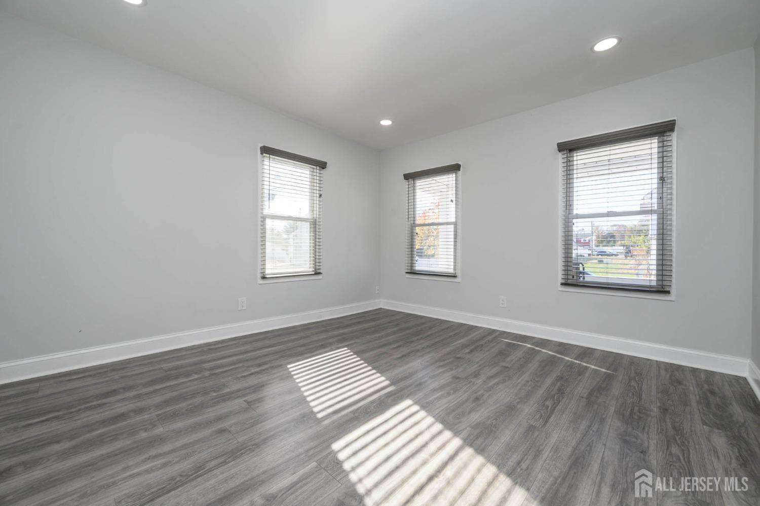 32 Lee Street Port Reading, NJ 07064 - Photo 3 of 32 a view of empty room with wooden floor and fan