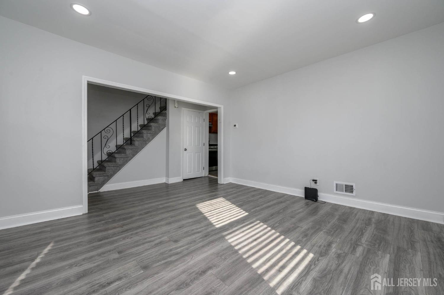 32 Lee Street Port Reading, NJ 07064 - Photo 5 of 32 a view of an empty room with wooden floor and stairs