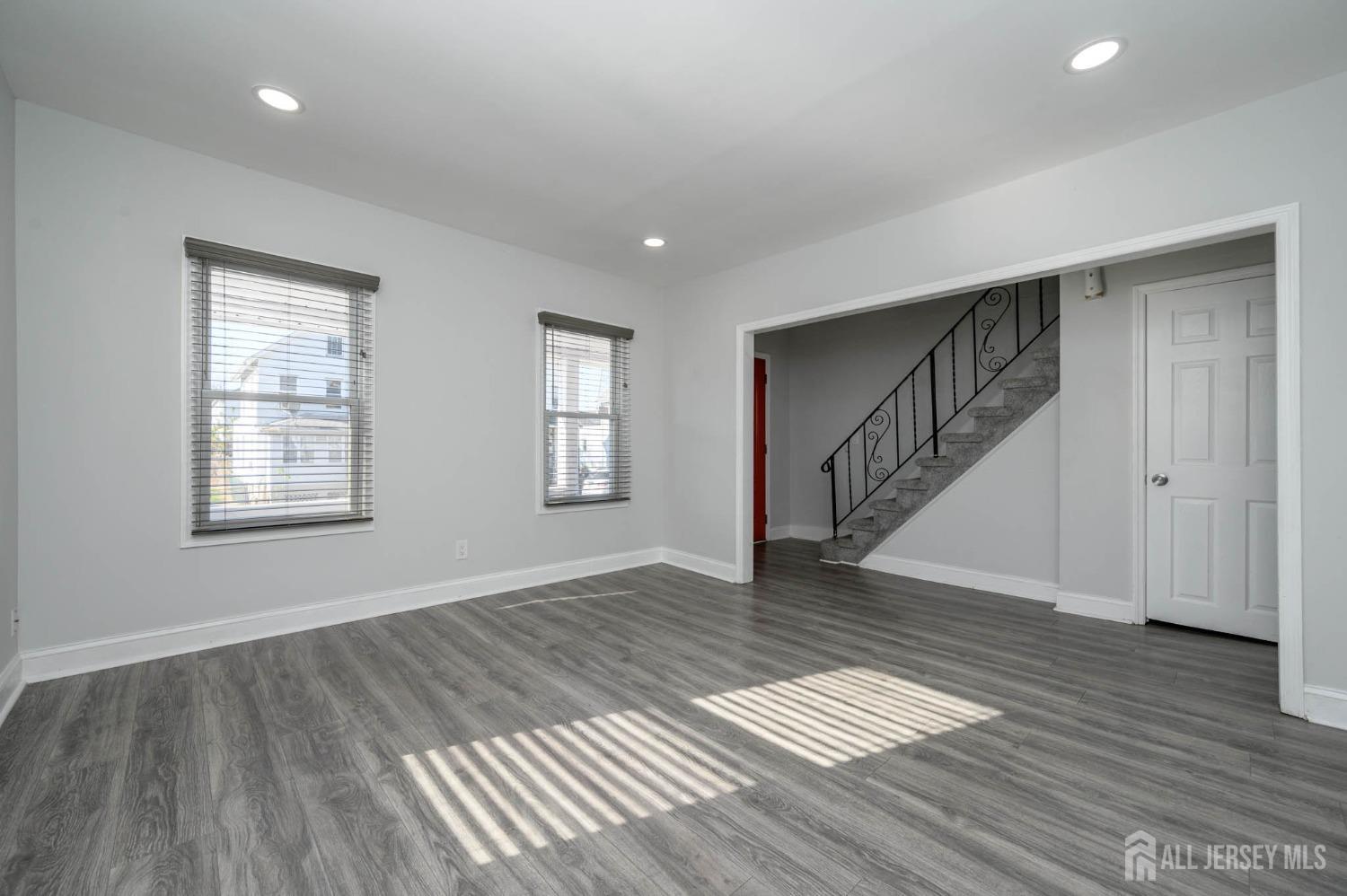 32 Lee Street Port Reading, NJ 07064 - Photo 6 of 32 a view of an empty room with wooden floor and stairs