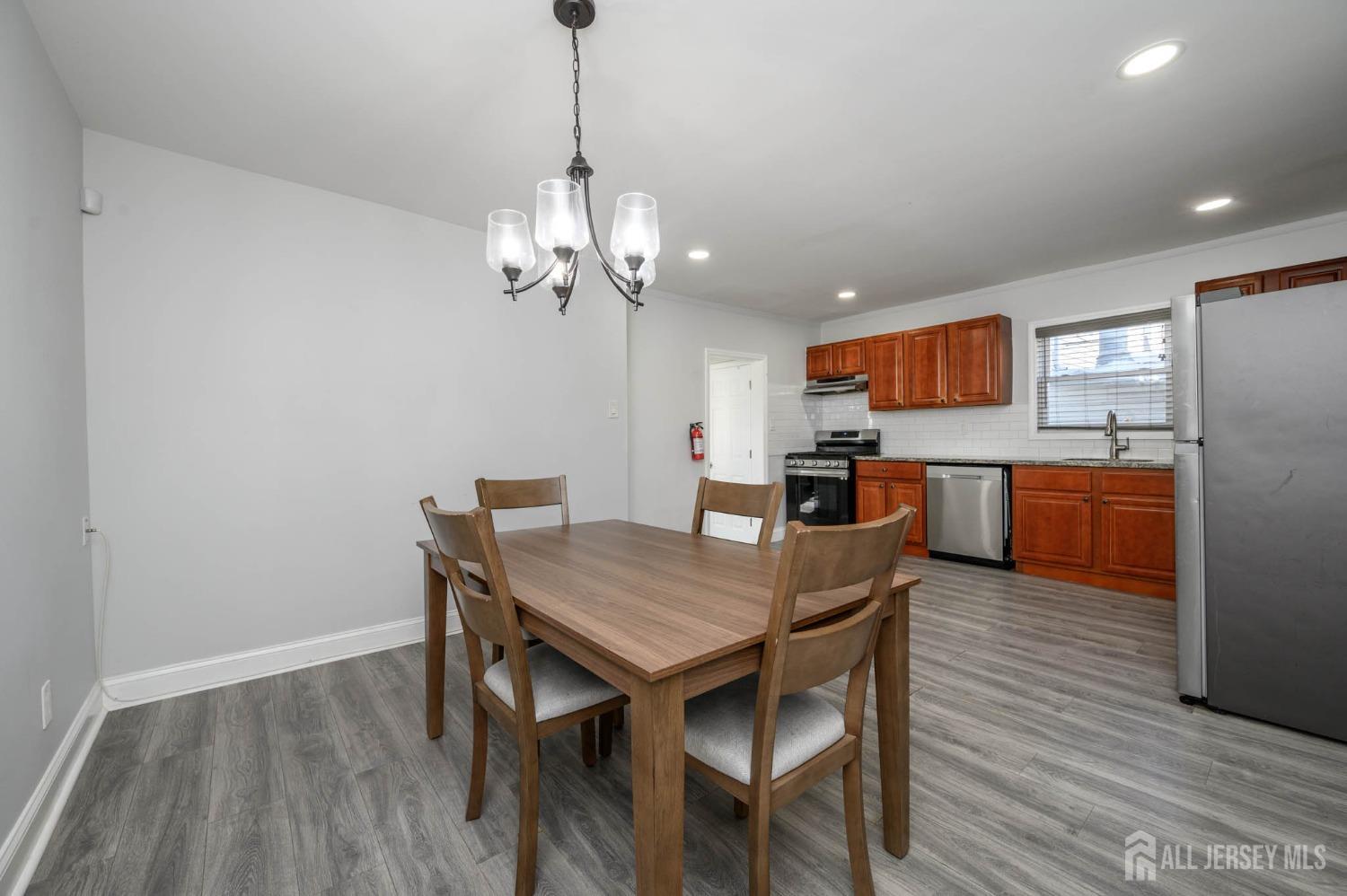 32 Lee Street Port Reading, NJ 07064 - Photo 10 of 32 a view of a dining room with furniture a chandelier and wooden floor
