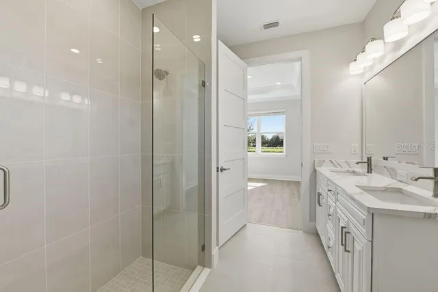 a bathroom with a double vanity sink and a mirror