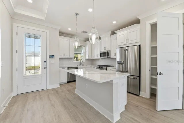 a kitchen with white cabinets and stainless steel appliances