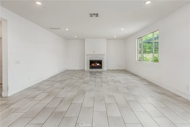 an empty room with fireplace and windows