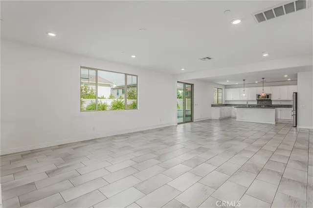 an empty room with a kitchen and a window