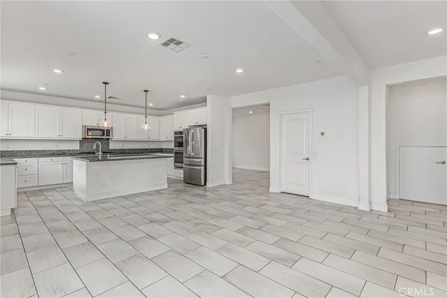 a kitchen with stainless steel appliances granite countertop a refrigerator and a stove top oven