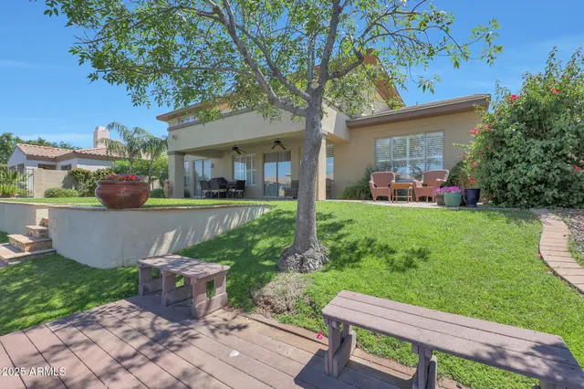 a front view of a house with garden and trees