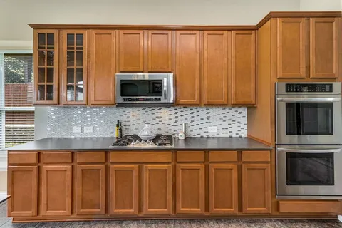 a kitchen with granite countertop wooden cabinets and stainless steel appliances