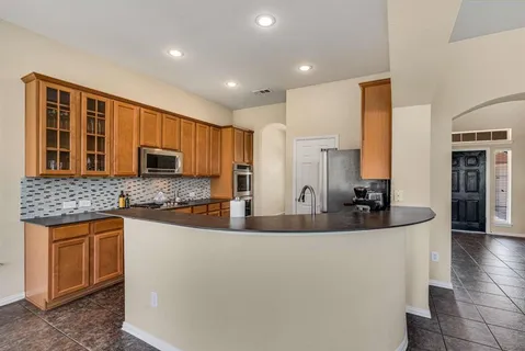 a kitchen with stainless steel appliances granite countertop a sink a stove and a refrigerator