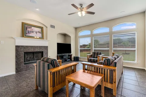 a living room with furniture a flat screen tv and a large window