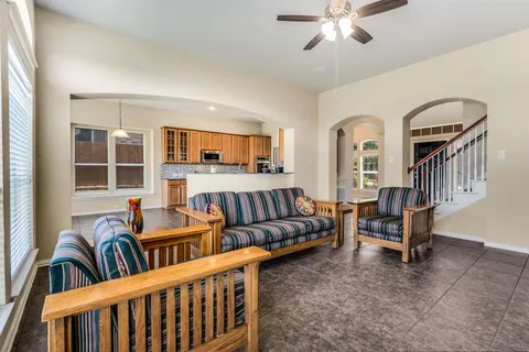 a living room with furniture kitchen view and a window
