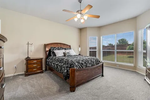 a bedroom with a bed and a large window