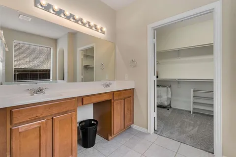a bathroom with a double vanity sink a mirror and a faucet