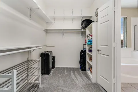 a view of walk in closet with clothes and shoes
