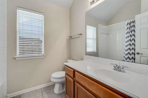 a bathroom with a granite countertop sink toilet and mirror