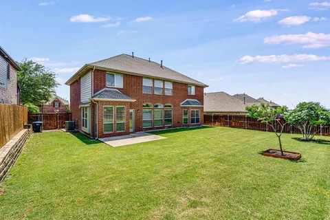 a view of an house with backyard and a tree