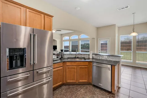 a kitchen with stainless steel appliances granite countertop a refrigerator sink and cabinets