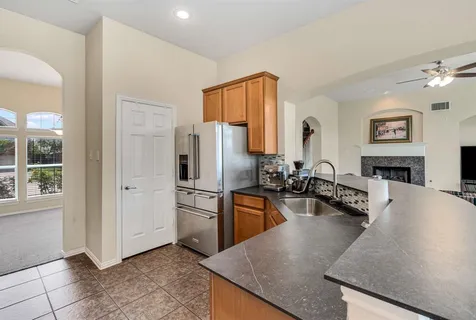 a kitchen with stainless steel appliances granite countertop a sink a stove and a refrigerator