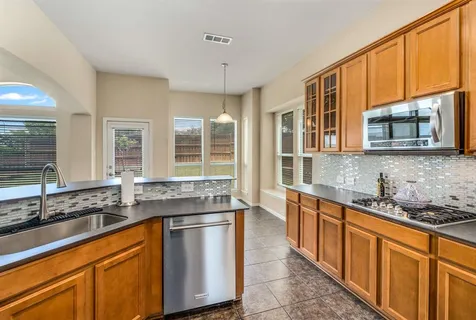 a kitchen with stainless steel appliances granite countertop a sink stove and cabinets