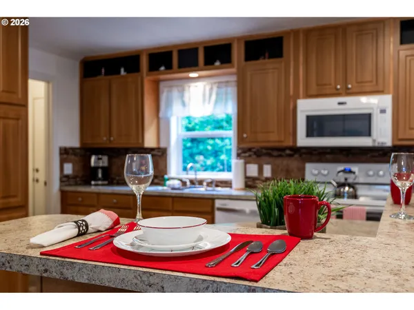 a kitchen with stainless steel appliances kitchen island granite countertop a refrigerator stove top oven and sink