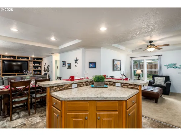 a kitchen with kitchen island a sink stove and view living room