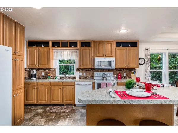 a kitchen with stainless steel appliances granite countertop a stove top oven a sink and cabinets