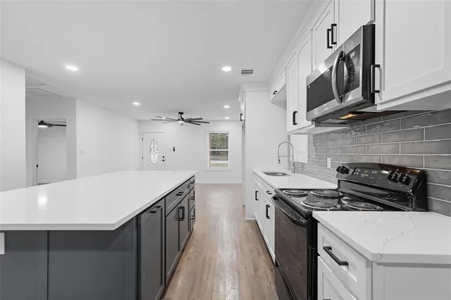 a kitchen with stainless steel appliances a sink stove and cabinets