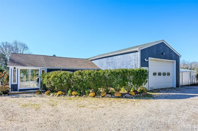 a front view of a house with a yard and potted plants