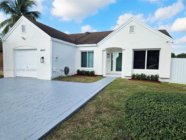 a view of a white house with a yard