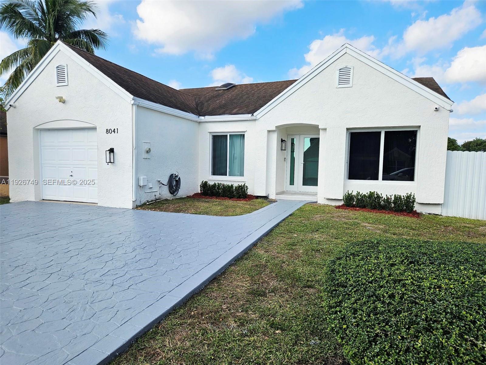 8041 Northwest 191st Street, Unit 8041 Hialeah, FL 33015 - Photo 1 of 11 a view of a white house with a yard