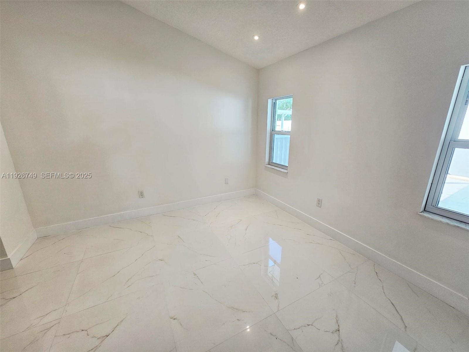 8041 Northwest 191st Street, Unit 8041 Hialeah, FL 33015 - Photo 5 of 11 an empty room with windows