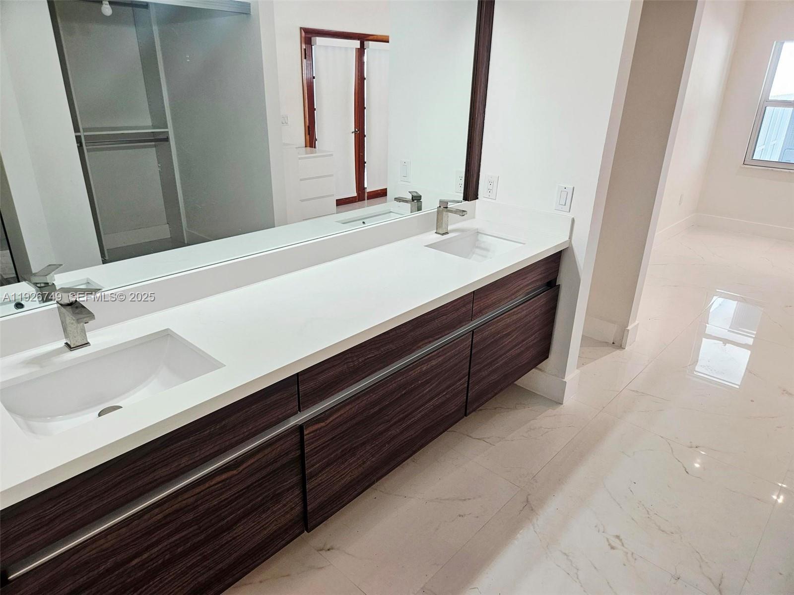 8041 Northwest 191st Street, Unit 8041 Hialeah, FL 33015 - Photo 6 of 11 a bathroom with a double vanity sink and a mirror