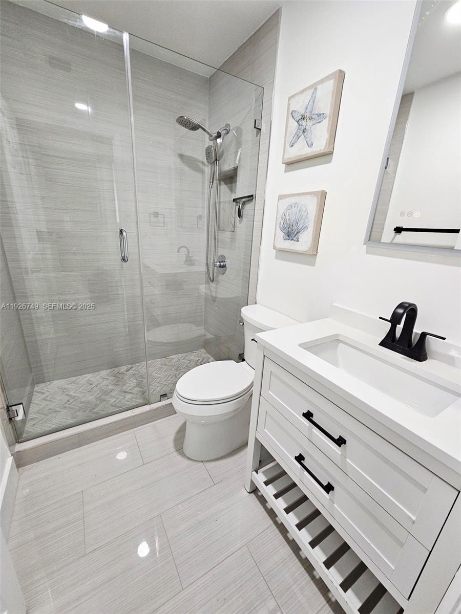 8041 Northwest 191st Street, Unit 8041 Hialeah, FL 33015 - Photo 10 of 11 a bathroom with a sink a toilet and a shower