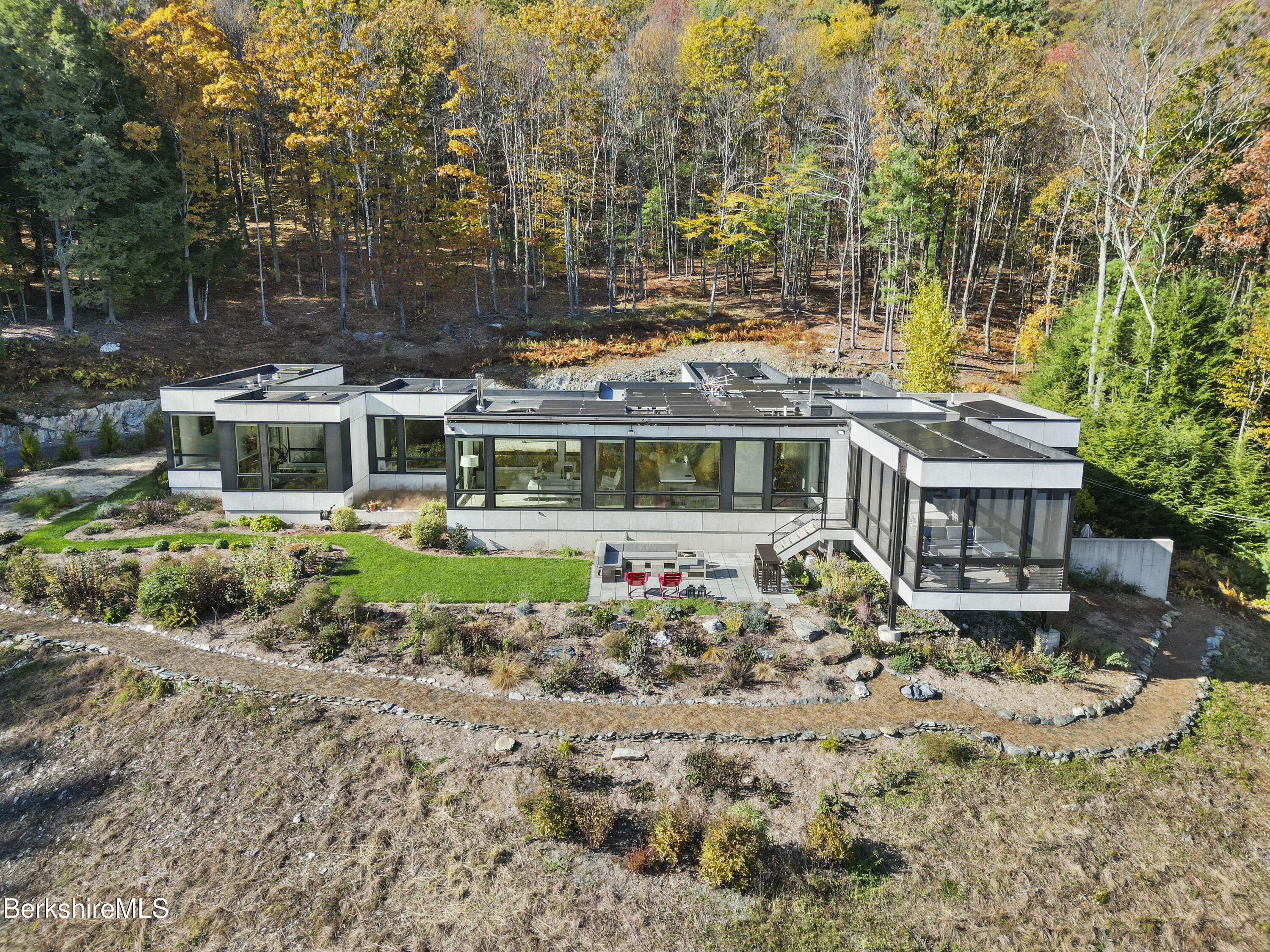 an aerial view of a house with a yard lake and outdoor seating