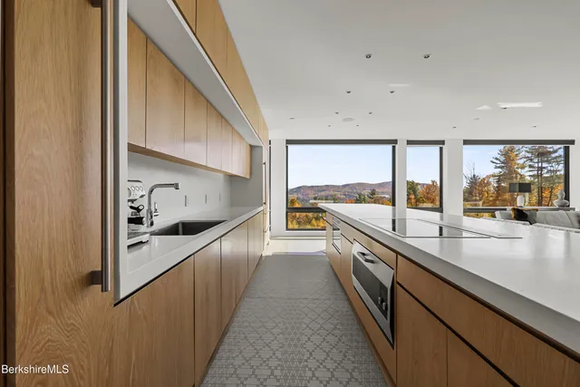 a large kitchen with stainless steel appliances a large counter top and a stove