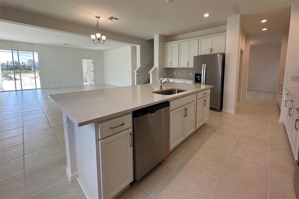 761 Farfields Street DeLand, FL 32724 - Photo 6 of 11 a kitchen with stainless steel appliances granite countertop a sink a refrigerator and a stove